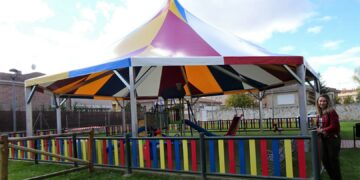 Los más pequeños disfrutan del juego seguro protegidos del sol y la lluvia con la colorida carpa instalada en el parque de la carretera de Naharros