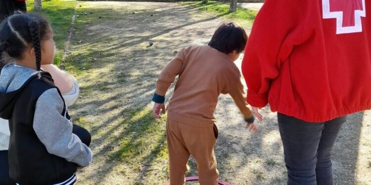El Club de Petanca Villamayor enseña a los niños del Centro Infantil de Cruz Roja a jugar a este deporte tradicional