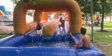 Los hinchables de agua convierten la calle Carpihuelo en un parque acuático como fin de fiestas